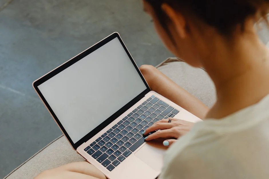 A neat workspace featuring a sketchpad with wireframes, a smartphone, and a keyboard on a wooden desk.